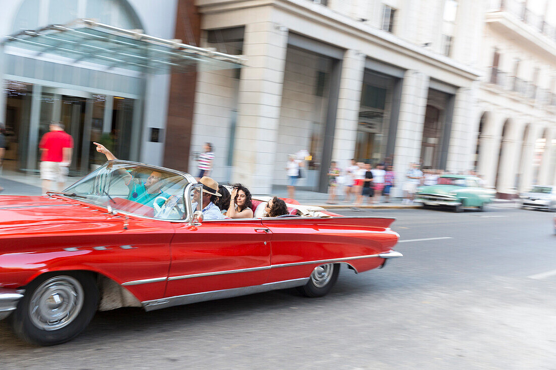 red oldtimer, cabriolet driving along Pado and Paseo de Marti, historic town, center, old town, Habana Vieja, Habana Centro, family travel to Cuba, holiday, time-out, adventure, Havana, Cuba, Caribbean island