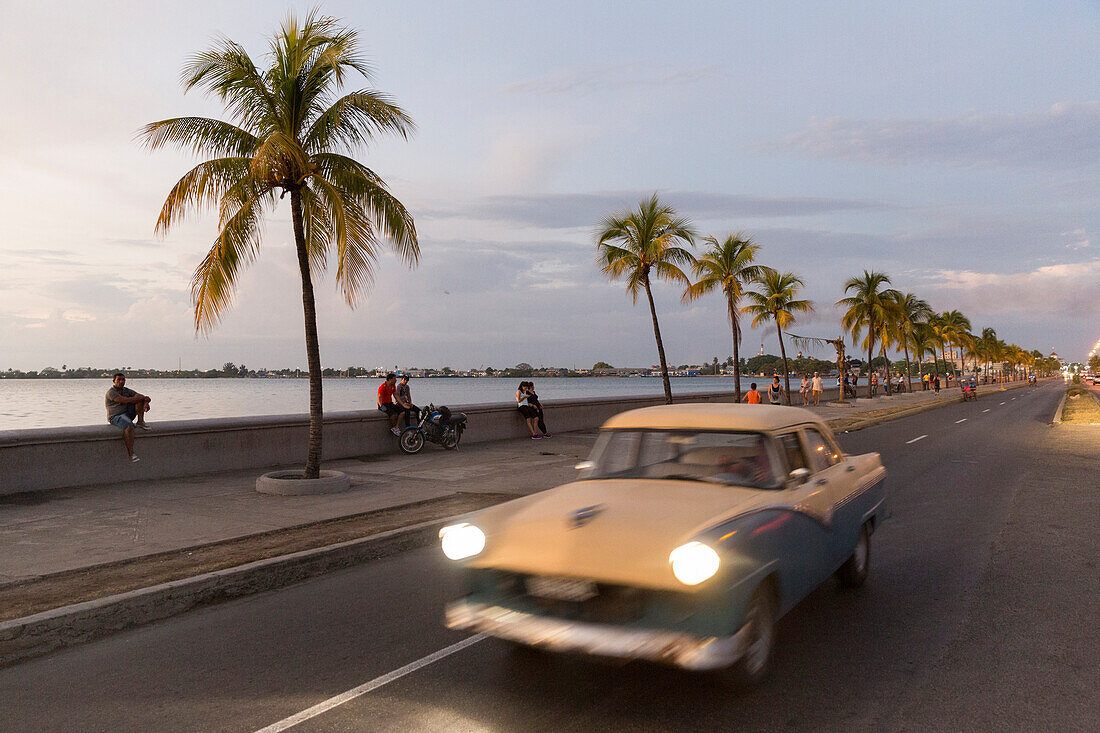 Oldtimer auf dem Malecon von Cienfuegos, abendlicher Treffpunkt, Nachtleben, wenig befahrene Straße, gut erhaltene koloniale Altstadt, am Meer, Perle des Südens, Familienreise nach Kuba, Auszeit, Elternzeit, Urlaub, Abenteuer, Cienfuegos, Republik Kuba, k