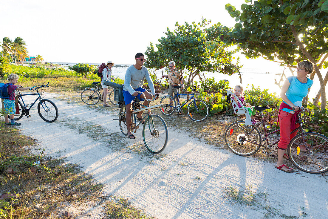 family on a bicycle tour, lonely coast road from La Boca to Playa Ancon, with beautiful small sandy beaches in between, at the beach, turquoise blue sea, family travel to Cuba, parental leave, holiday, time-out, adventure, near Trinidad and La Boca, Cuba,