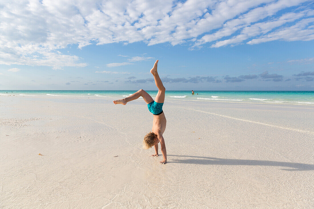 boy 6 years doing a handstand on the beach, tourists at the most beautiful beach in Cayo Guillermo, Playa Pilar, sandy dream beach, turquoise blue sea, swimming, family travel to Cuba, parental leave, holiday, time-out, adventure, MR, Playa Pilar, Cayo Gu