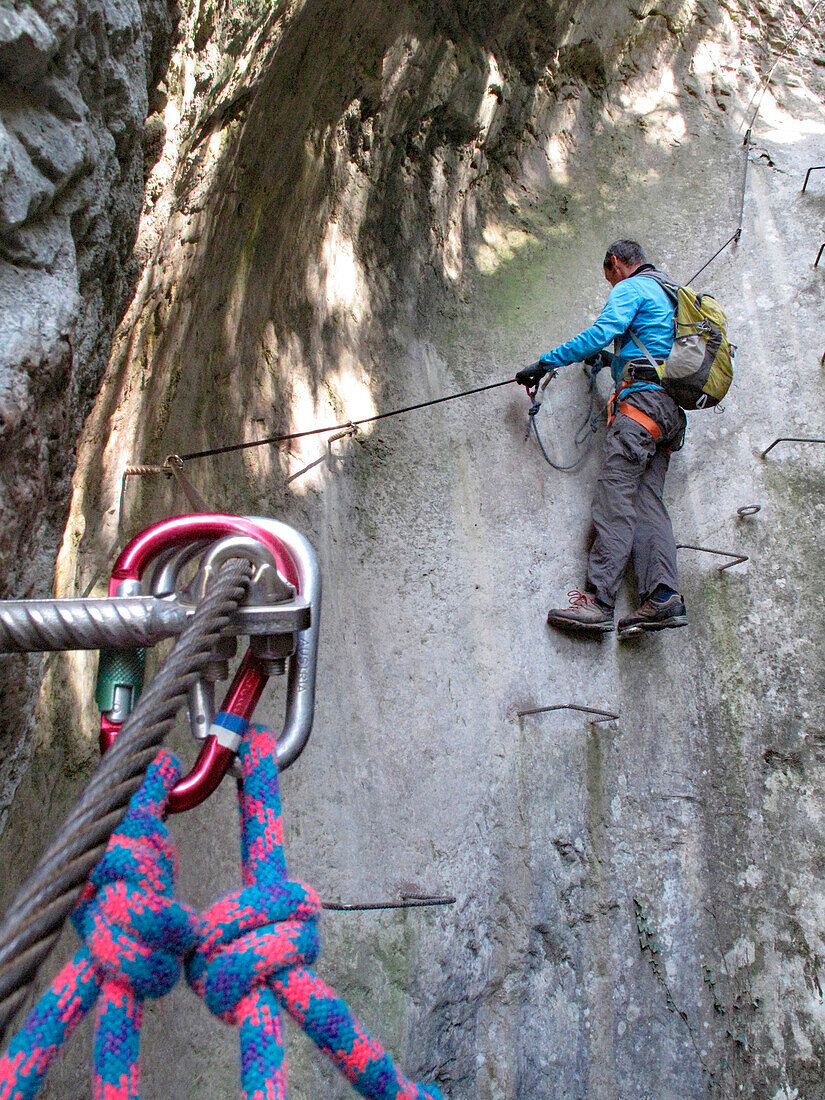 North Italy, Trentino,Arco,via ferrata of the Sallagoni river, a man wearing a harness climbs on a cliff equipped with a via ferrata