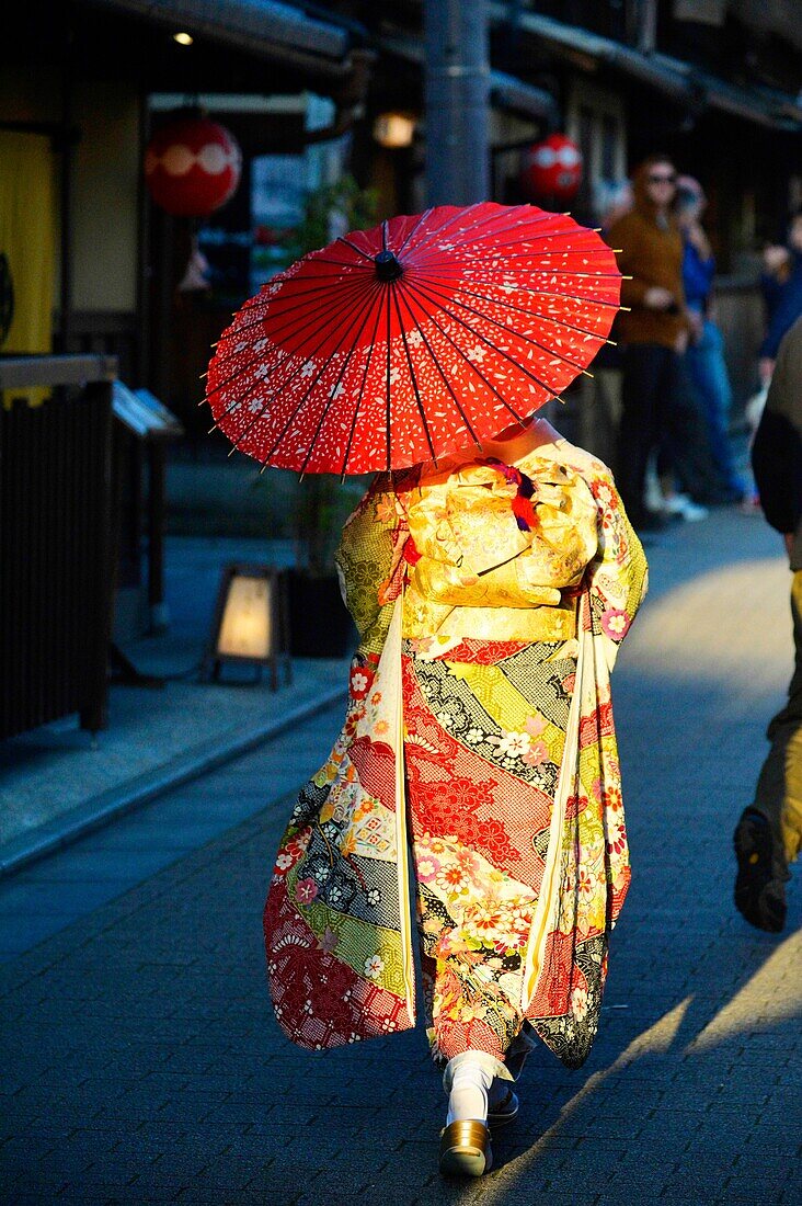 Japanese woman in a traditional kimono dress with a red umbrella,Kyoto, Japan,Asia
