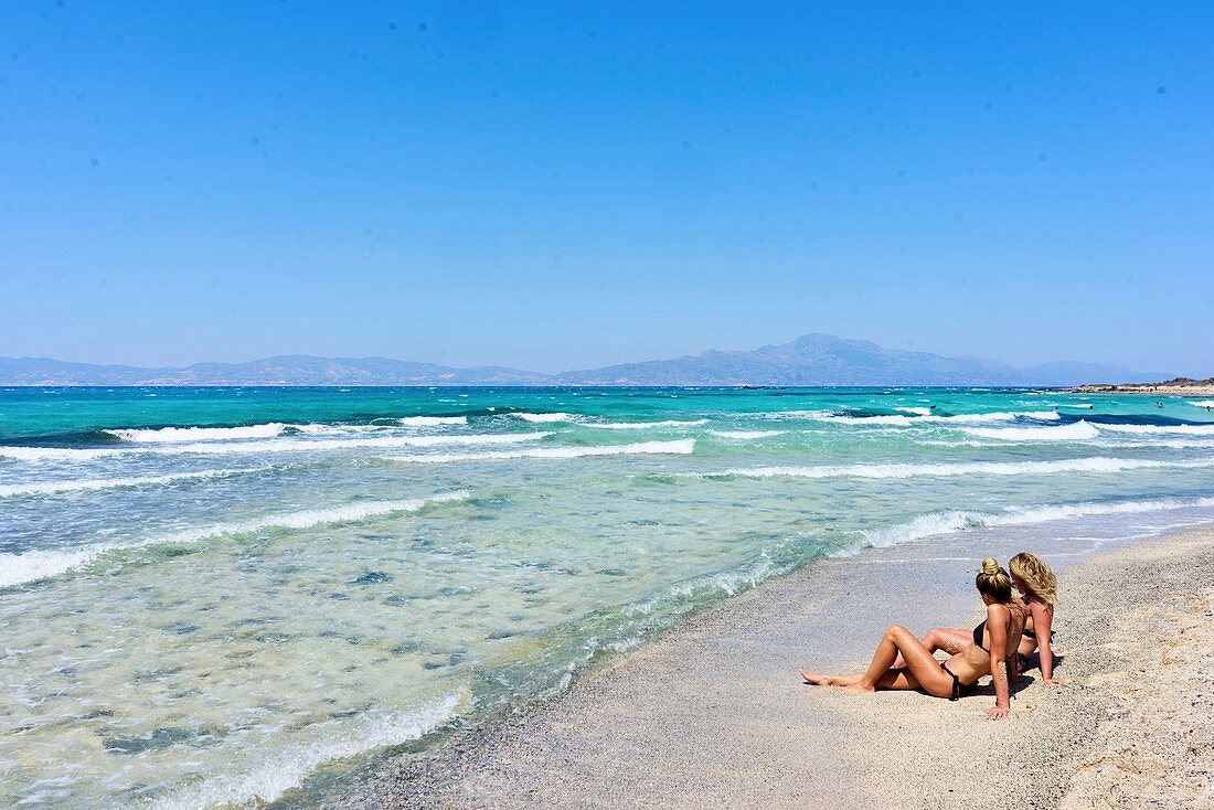 Two young women, best friends, sitting together on the beach, Dutch ethnicity, At holiday destination Chrissi Island, Crete, Greece