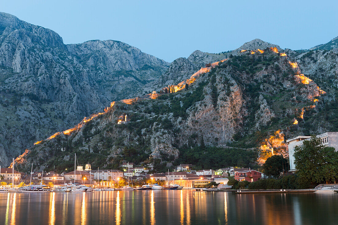 Venetian built fort with bastions highlighted by lights at twilight, Kotor, Montenegro, Europe