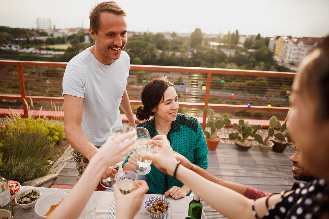 Happy male and female friends toasting wineglasses on patio