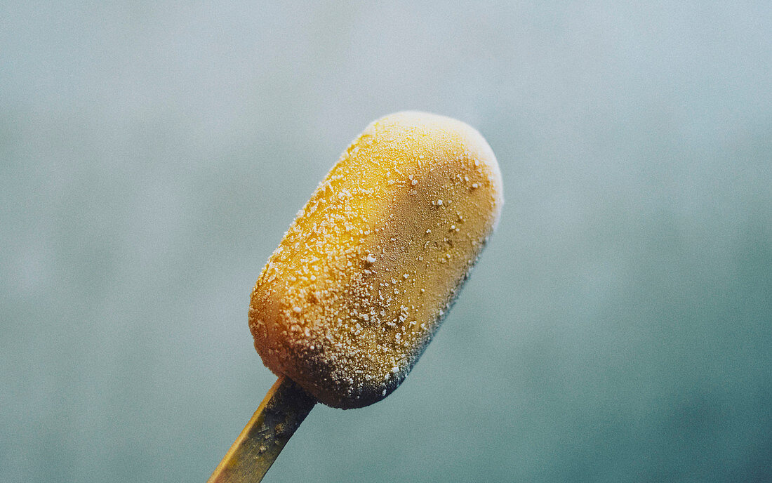 Close-up of yellow ice cream on stick