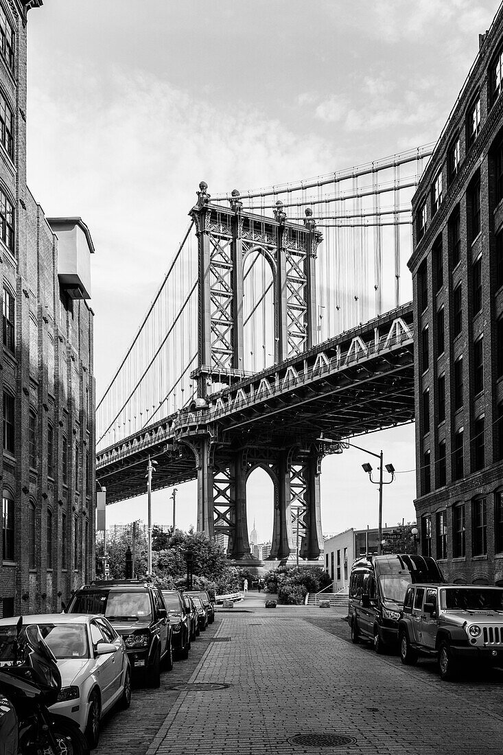 Manhattan Bridge against sky seen from street in city, New York City, New York, USA