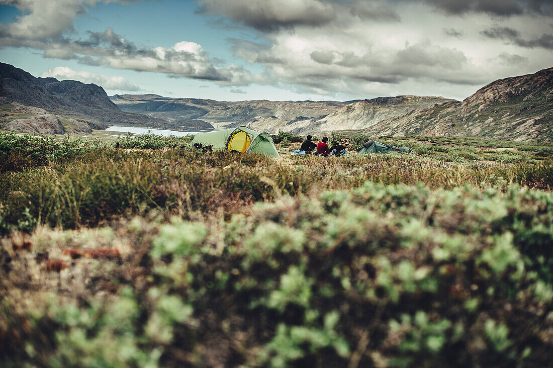 Hiker in front of two tents in greenland, greenland, arctic.