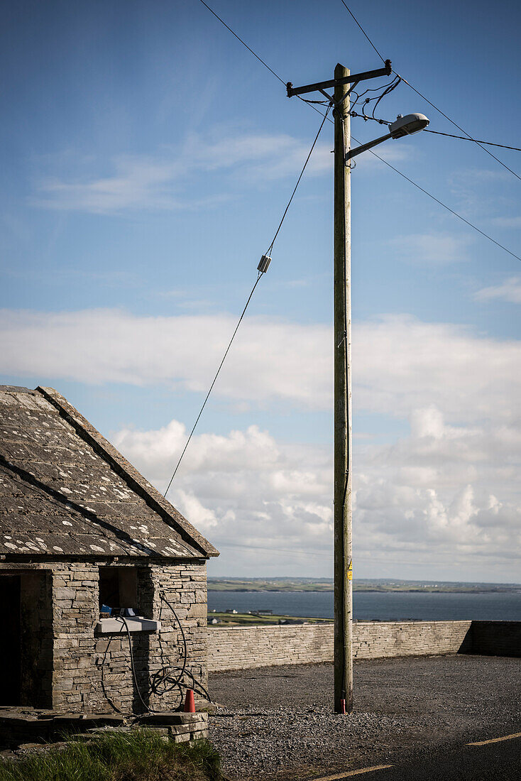 traditionelles irisches Steinhaus mit Strommast, Grafschaft Clare, Irland, Europa