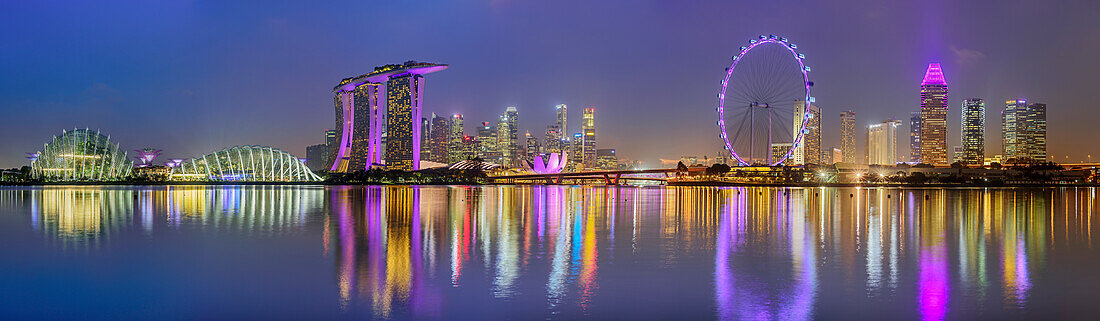 Panorama mit beleuchtete Skyline von Singapur mit Flower Dome, Marina Bay Sands, ArtScience Museum und Singapore Flyer, spiegelt sich in Marina Bay, Singapur