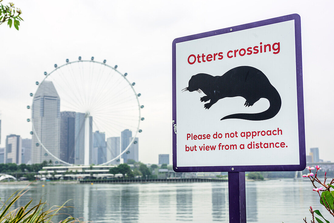 Signpost with otter and skyscrapers in background, Marina Bay, Singapore