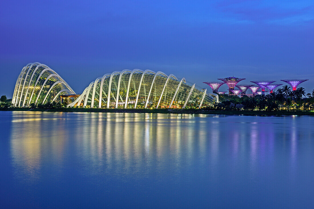 Illuminated Garden of the Bay with Cloud Forest, Flower Dome and SuperTrees reflecting in Marina Bay, Singapore