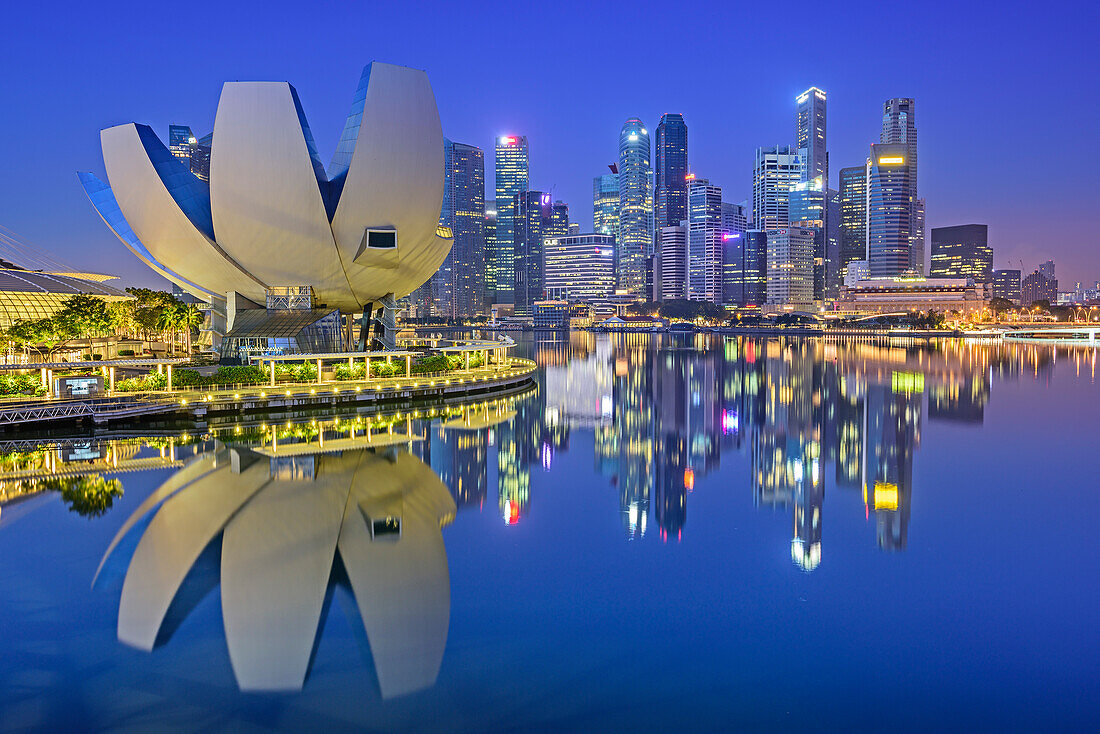 Illuminated skyline of Singapore with ArtScience Museum and Financial District reflecting in Marina Bay, Singapore