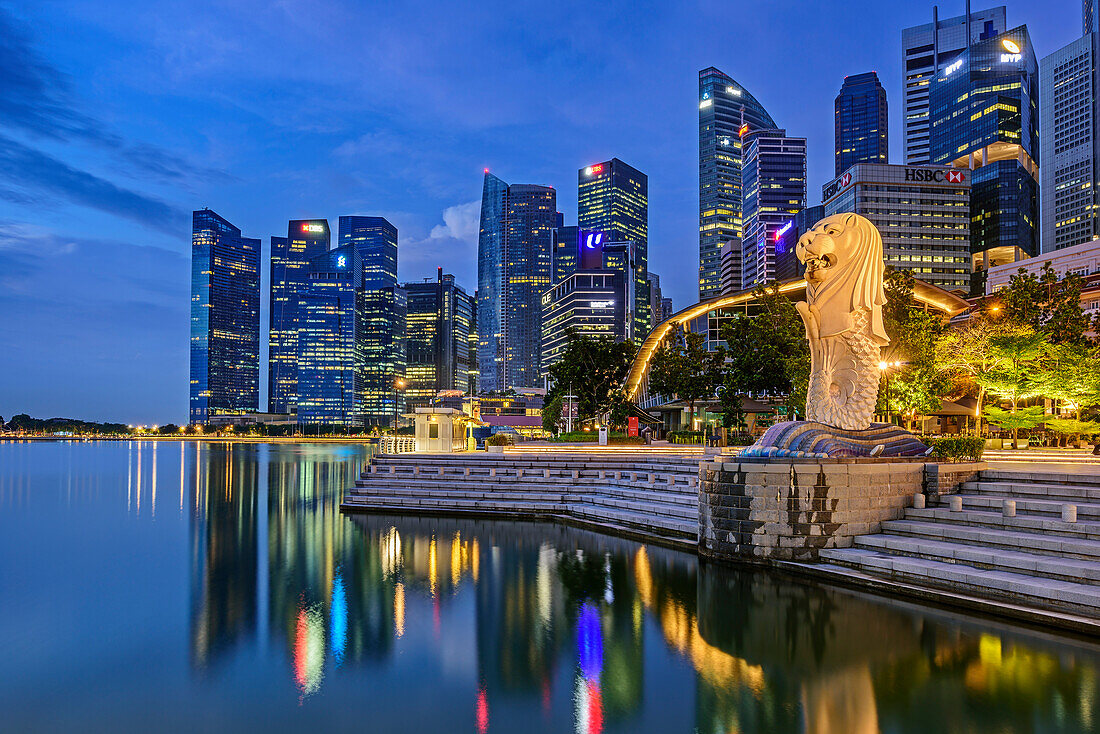 Illuminated gargoyle Merlion with Financial District reflecting in Marina Bay, Marina Bay, Singapore