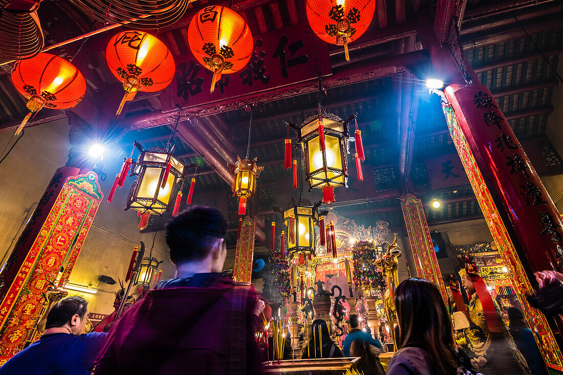 Praying inside the Taoist Man Mo Temple, Hong Kong, China, Asia