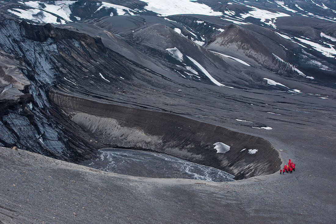 Passengers of expedition cruise ship MS Bremen (Hapag-Lloyd Cruises) look into a deep crater, Telefon Bay, Deception Island, South Shetland Islands, Antarctica