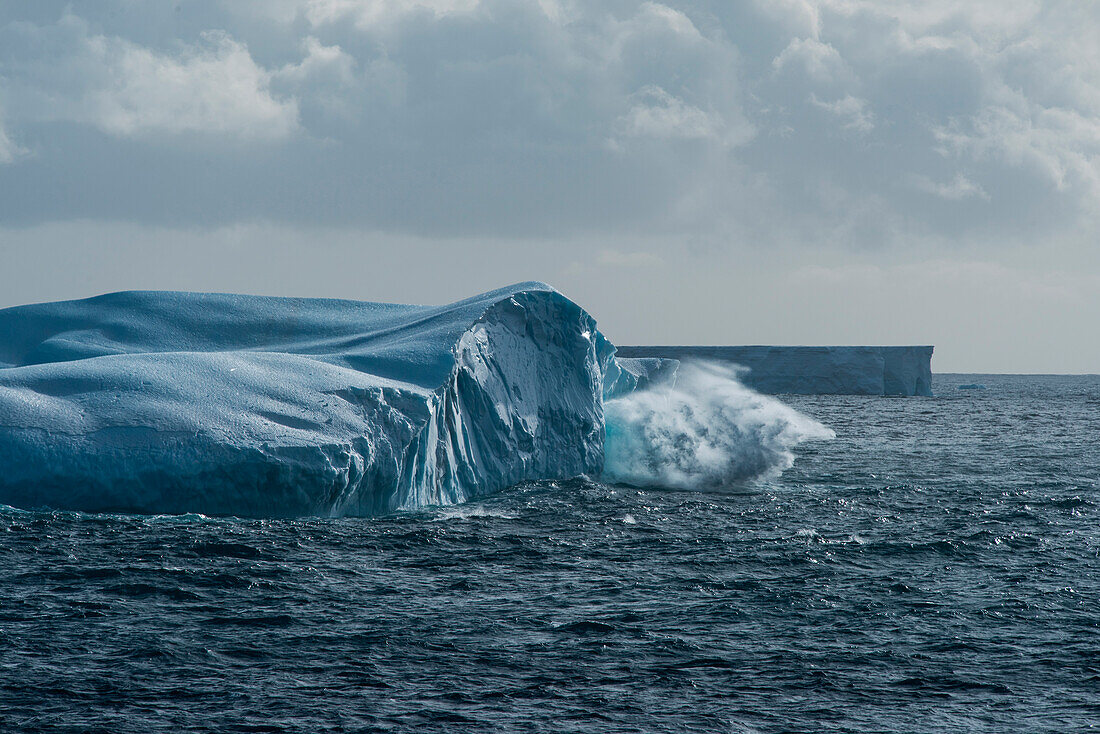 A wave crashes against an iceberg, near Cape Adare, Antarctica
