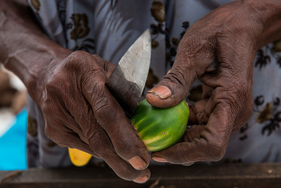Detail von dunklen Händen mit schmutzigen Fingernägeln die eine Betelnuss halten, Kavieng, New Ireland, Papua-Neuguinea, Südpazifik