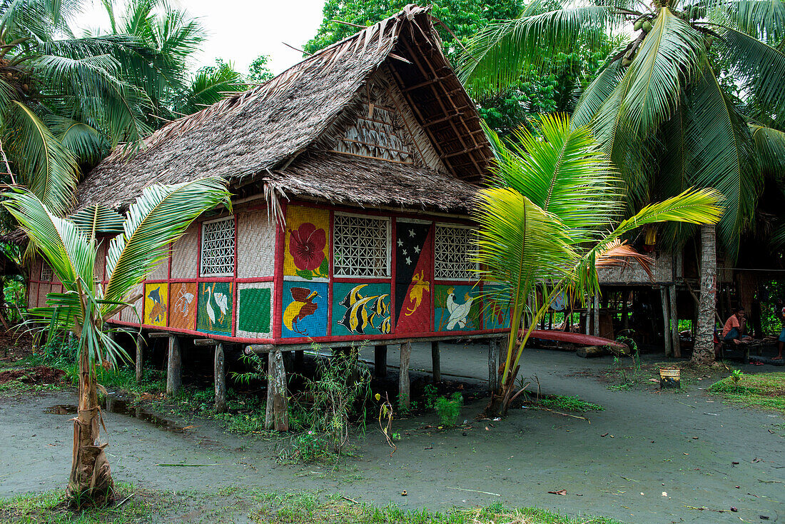 Die Seiten eines mit Palmwedeln überdachten Hauses sind mit farbenfrohen Gemälden von Tieren bedeckt, Kopar, East Sepik, Papua-Neuguinea, Südpazifik
