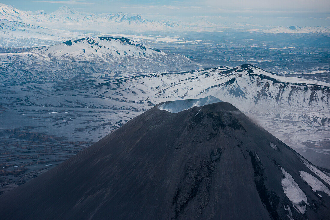 Luftaufnahme von Vulkan Karymsky (Stratovulkan) mit aufsteigendem Dampf aus der Kaldera vom Hubschrauber aus gesehen, nahe Petropavlovsk-Kamchatsky, Kamtschatka, Russland, Asien