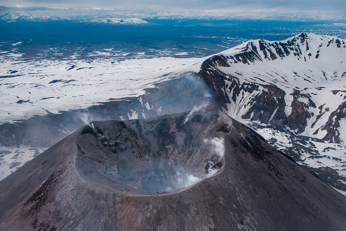 Aerial of the Karymsky Volcano (Stratovolcano) with steam rising from its caldera seen from helicopter, near Petropavlovsk-Kamchatsky, Kamchatka, Russia, Asia
