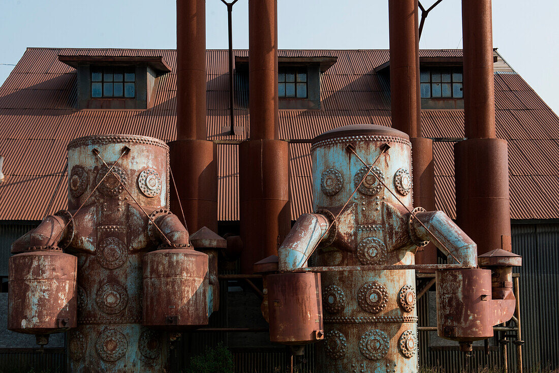 Verrostete Metalltanks vor einem Fabrikgebäude sehen fast menschlich aus, Nome, südliche Seward Halbinsel, Alaska, USA, Nordamerika