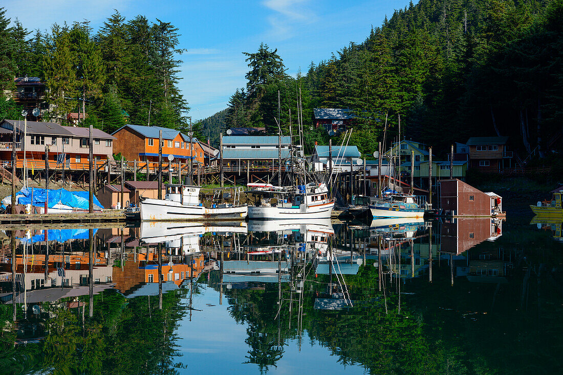 Fischerboote und die Ortschaft Elfin Cove spiegeln sich im ruhigen Wasser des Hafens wider, Elfin Cove, Chichagof Island, Alaska, USA, Nordamerika