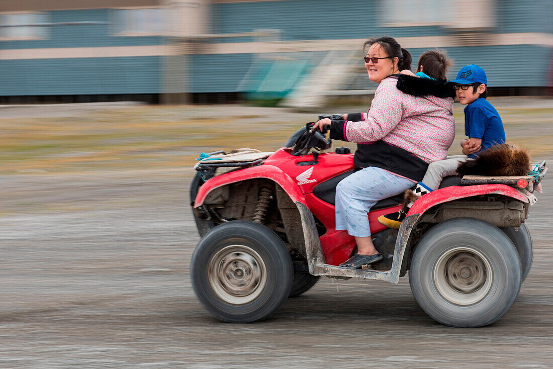 Frau fährt mit kleinen Kindern auf Quad, Ulukhaktok (Holman), Victoria Island, Nordwest-Territorien, Kanada, Nordamerika