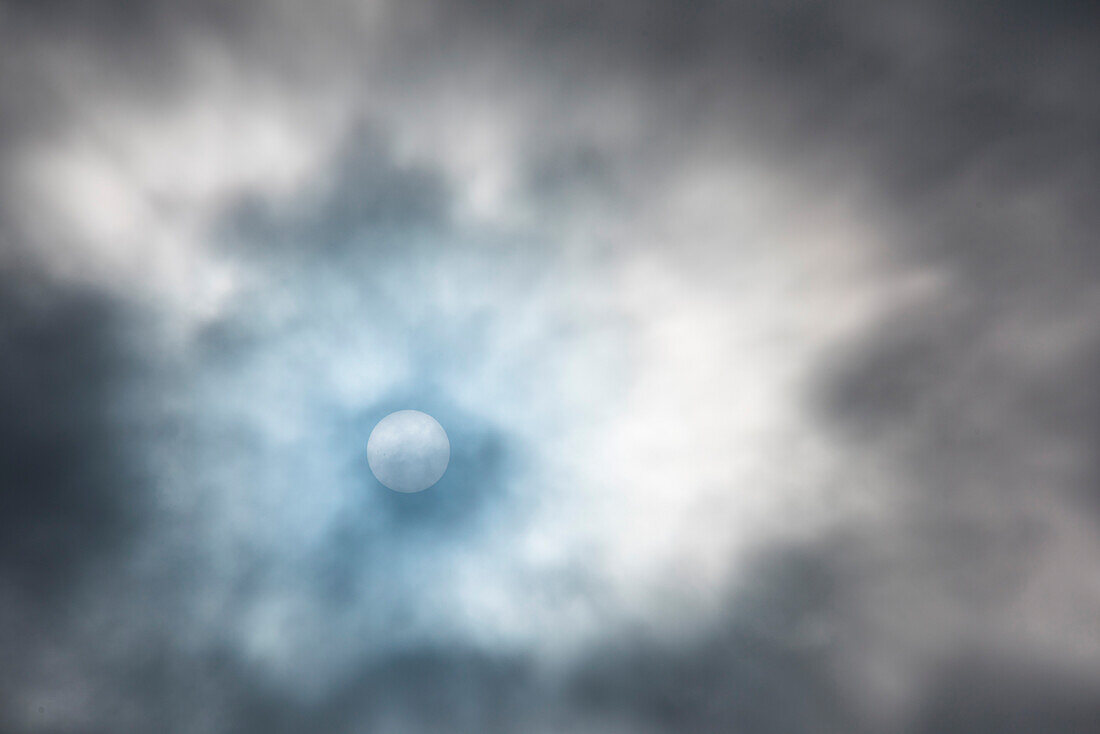 The sun just barely shines through the clouds, seen from aboard expedition cruise ship MS Bremen (Hapag-Lloyd Cruises), Fury and Hecla Strait, Nunavut, Canada, North America