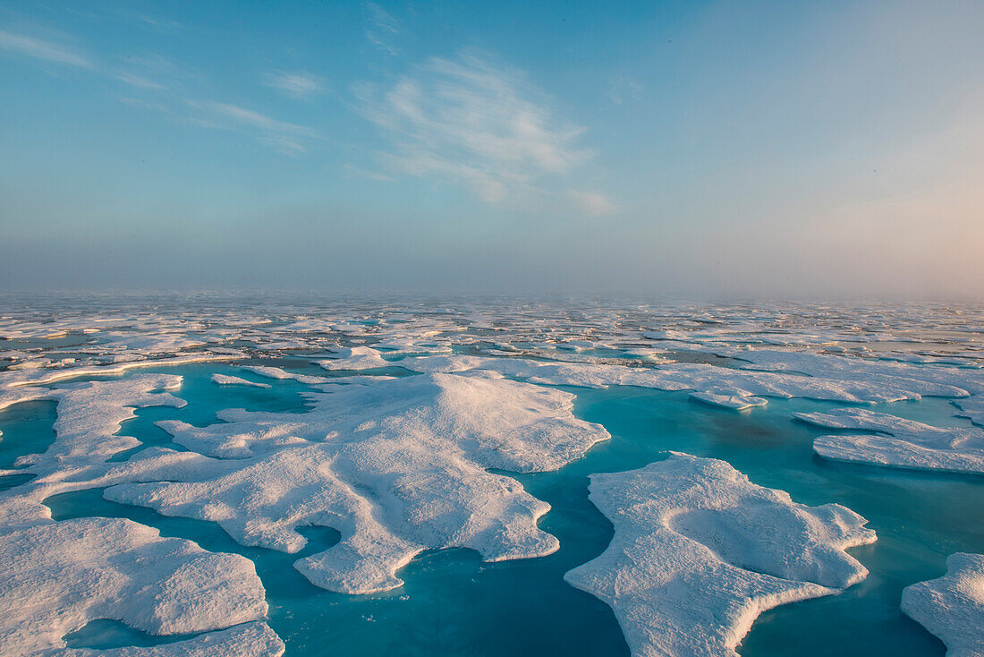 Blauer Himmel und ein Meer aus Eis mit türkisblauen Wasserbecken, die das sichtbare Eis wie Inseln aussehen lassen, vor Prince of Wales Island, Nunavut, Kanada, Nordamerika