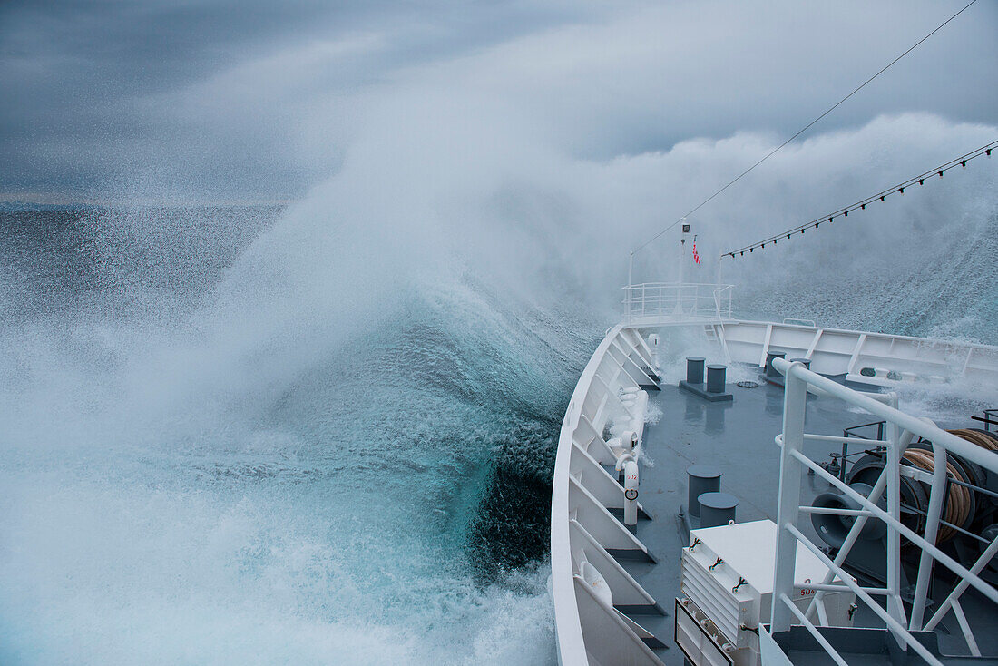 Bug von Expeditions-Kreuzfahrtschiff MS Bremen (Hapag-Lloyd Cruises) erzeugt große Nebelwolke und Spritzwasser bei Begegnung mit großer Welle bei schwerem Seegang, auf See, nahe Südwesten von Grönland