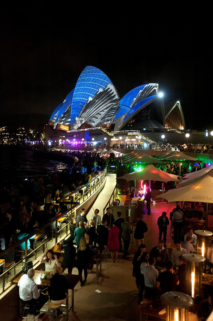 The lit-up Opera House with Opera Bar during the Vivid Festival, Sydney, New South Wales, Australia
