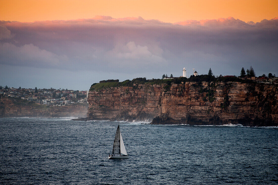 View to the sandstone cliffs of South Head with Macquarie Lighthouse in the background, Sydney, New South Wales, Australia
