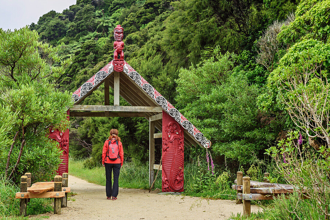 Frau wandert durch Eingangstor des Abel Tasman Coastal Track, Abel Tasman Coastal Track, Great Walks, Abel Tasman Nationalpark, Tasman, Südinsel, Neuseeland