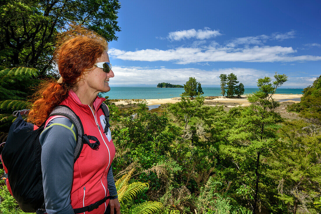 Frau beim Wandern blickt auf Meeresbucht, Abel Tasman Coastal Track, Great Walks, Abel Tasman Nationalpark, Tasman, Südinsel, Neuseeland