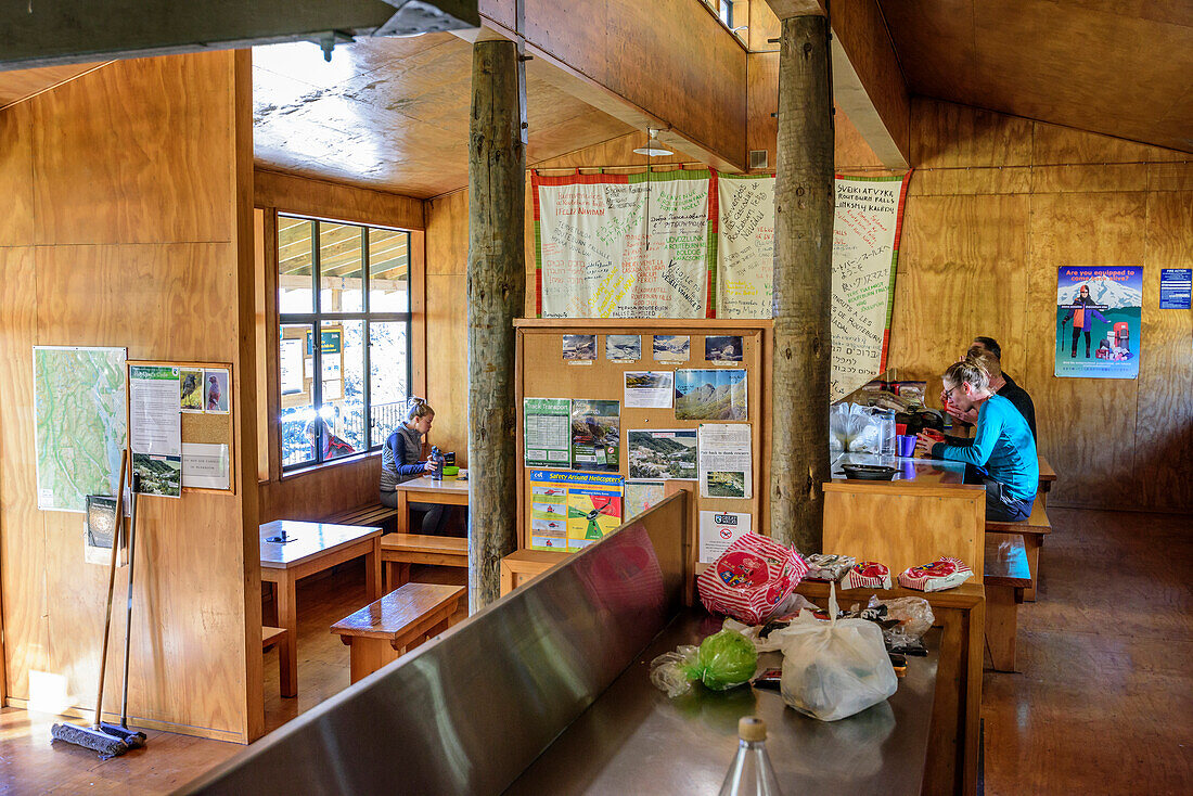 Several persons sitting in Routeburn Falls Hut, Routeburn Track, Great Walks, Fiordland National Park, UNESCO Welterbe Te Wahipounamu, Queenstown-Lake District, Otago, South island, New Zealand