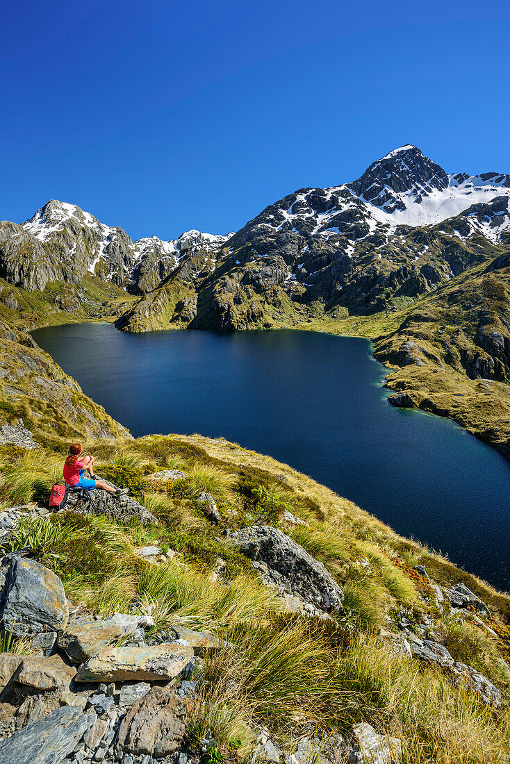 Frau beim Wandern blickt auf Harris Lake, Routeburn Track, Great Walks, Fiordlands Nationalpark, UNESCO Welterbe Te Wahipounamu, Queenstown-Lake District, Otago, Südinsel, Neuseeland