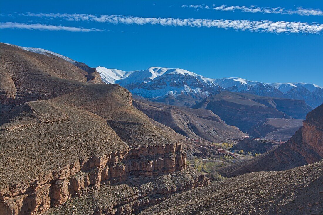 Canyon in the upper valley of the Dadés Gorge with a village and snowcapped mountains, High Atlas, Morocco