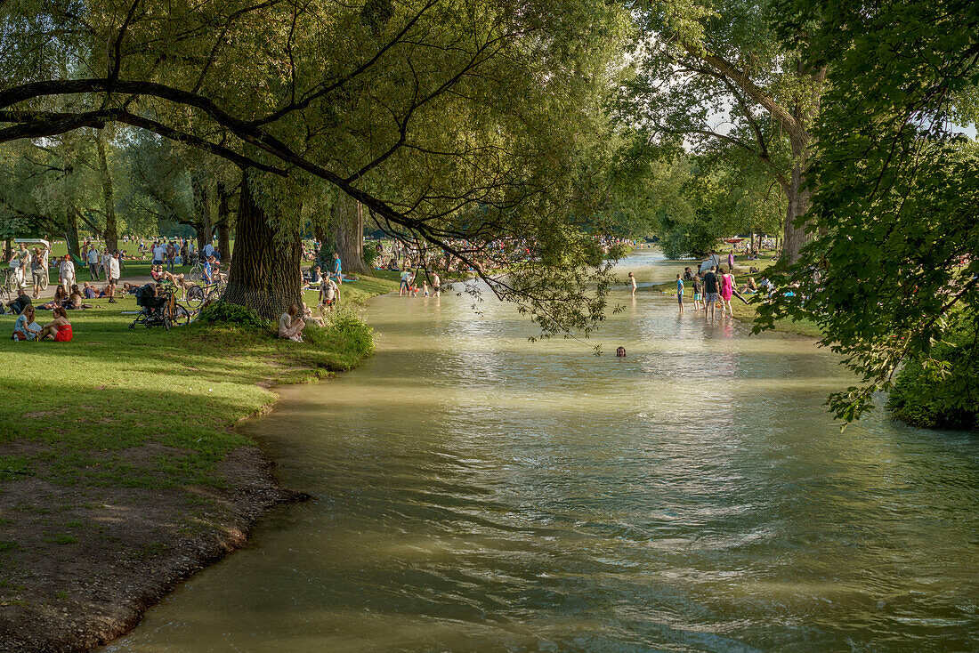 Menschen baden und verweilen am Eisbach im Englischen Garten, München, Oberbayern, Deutschland