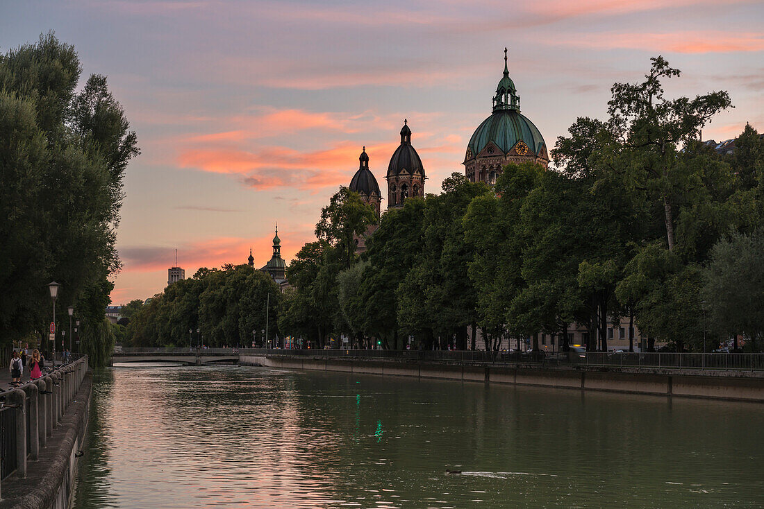 After sunset with view over the Isarkanal to church of St. Lukas and the tower of Deutsches Museum in the background, Munich, Upper Bavaria, Germany