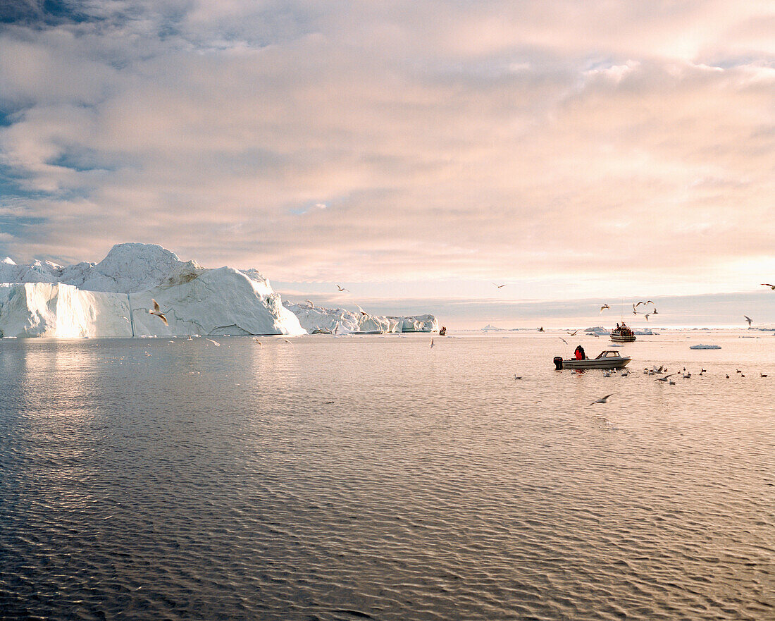 GREENLAND, Ilulissat, Ilulissat Icefjord, fishermen hunting for seals and fish with glaciers in the background