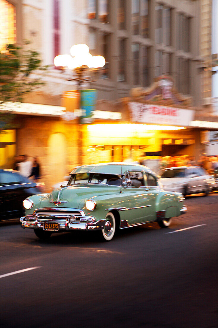 USA, California, San Diego, old cars speed off down the road near 5th Ave of the Gaslamp Quarter, a district of San Diego
