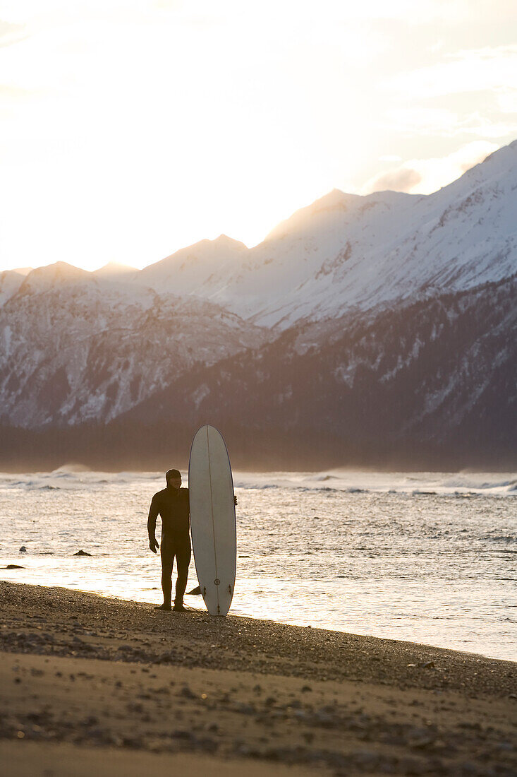 Surfer Standing With His Surfboard At Kachemak Bay, Homer Spit, Southcentral Alaska, USA