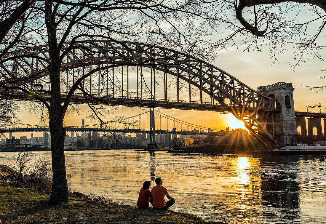 Couple Enjoying Sunset Near Hell Gate And Rfk Triboro Bridges, Ralph Demarco Park; Queens, New York, United States Of America