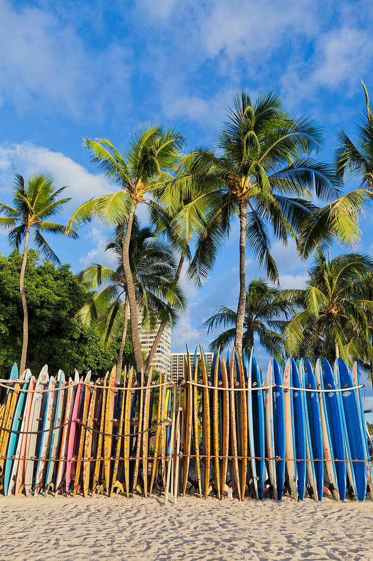 A rack of colourful surfboards lined up on Waikiki Beach; Honolulu, Oahu, Hawaii, United States of America