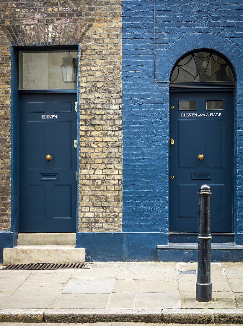 Two residential doorways side by side, one numbered eleven and the other eleven and a half, with differing facade and windows for each; London, England