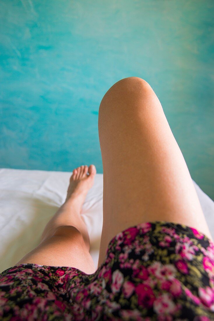 Woman's legs lying on a bed.