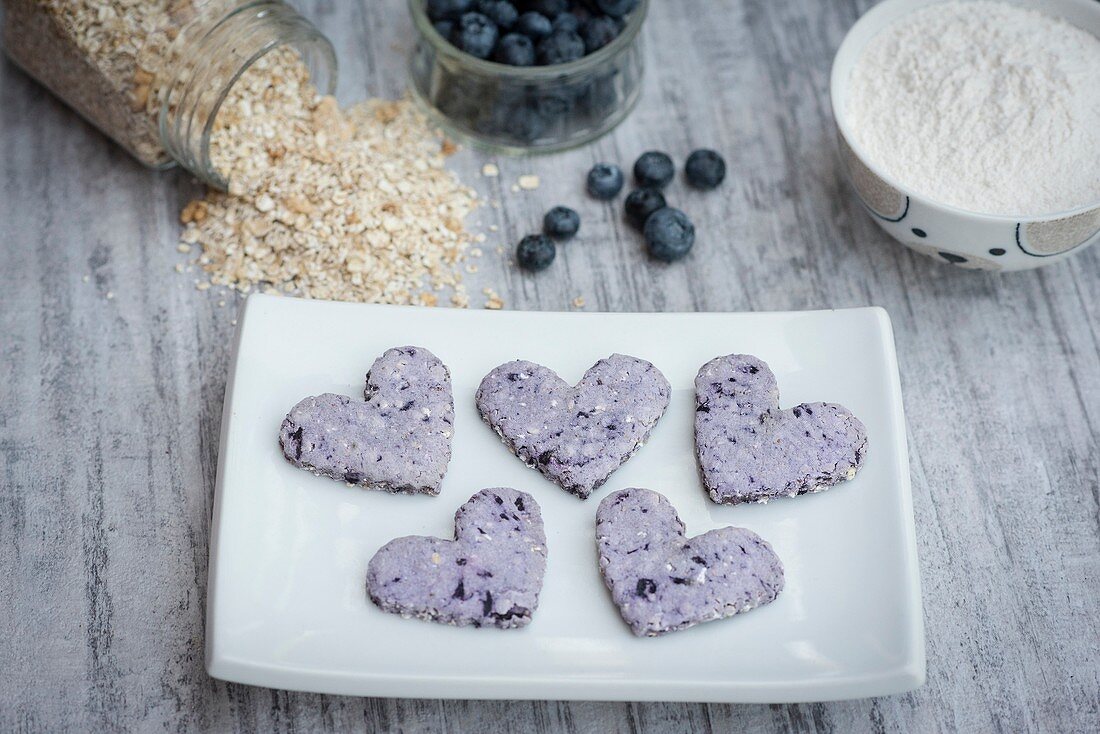 Heart sheaped blueberry cookies on a white plate.