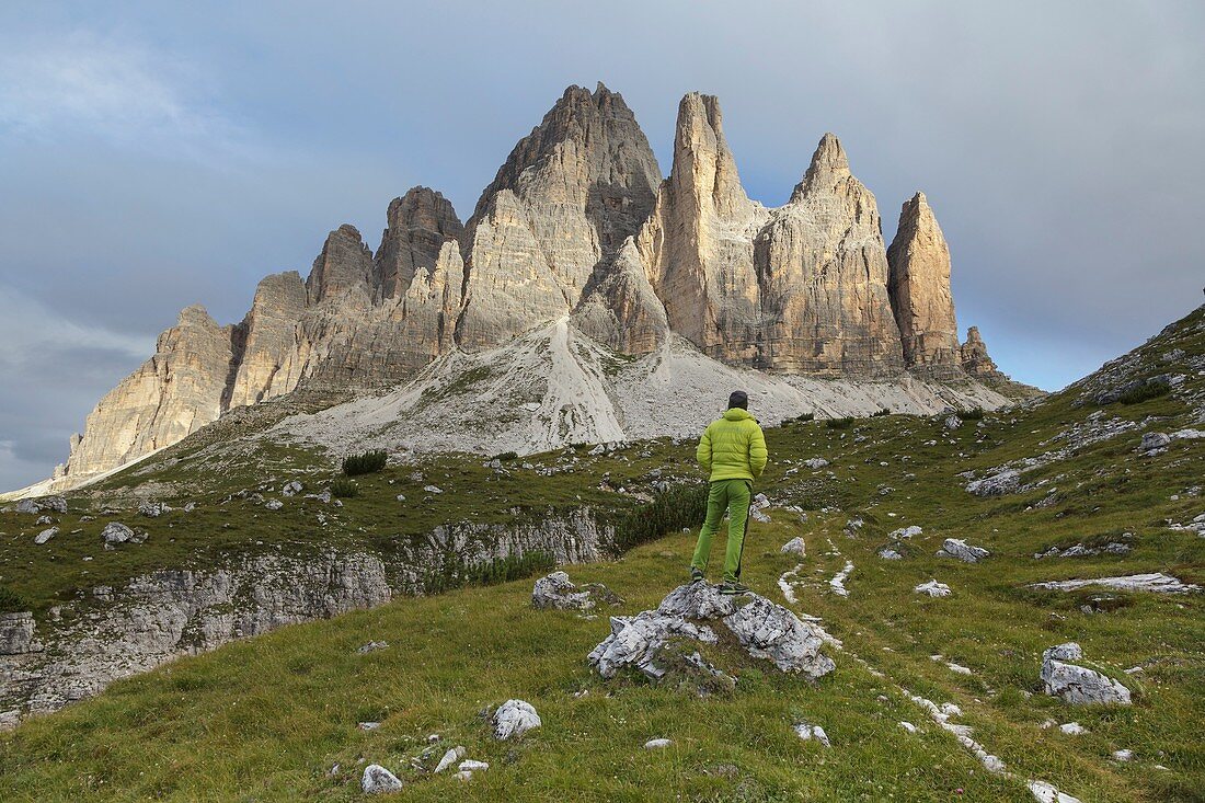 Europe, Italy, Veneto, Belluno. An hiker looking the Tre Cime di Lavaredo south side, Dolomites.