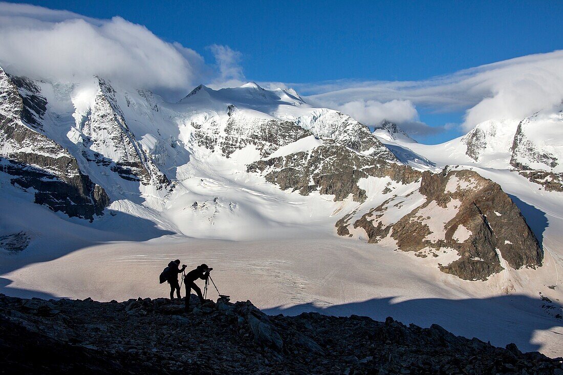 Photographers at Diavolezza Refuge, looking at Bernina glaciers. Diavolezza Refuge,Engadine, Canton of Graubunden,Switzerland Europe.